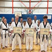 Peterborough instructor and Ely student Christopher Benstead, Wisbech student Charlotte Beck and Ely students Jack Steventon and Natalia Teli (Inset) with their black belt certificates.