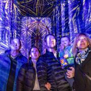 A family enjoying Luxmuralis' light and sound display 'The Manger' at Peterborough Cathedral